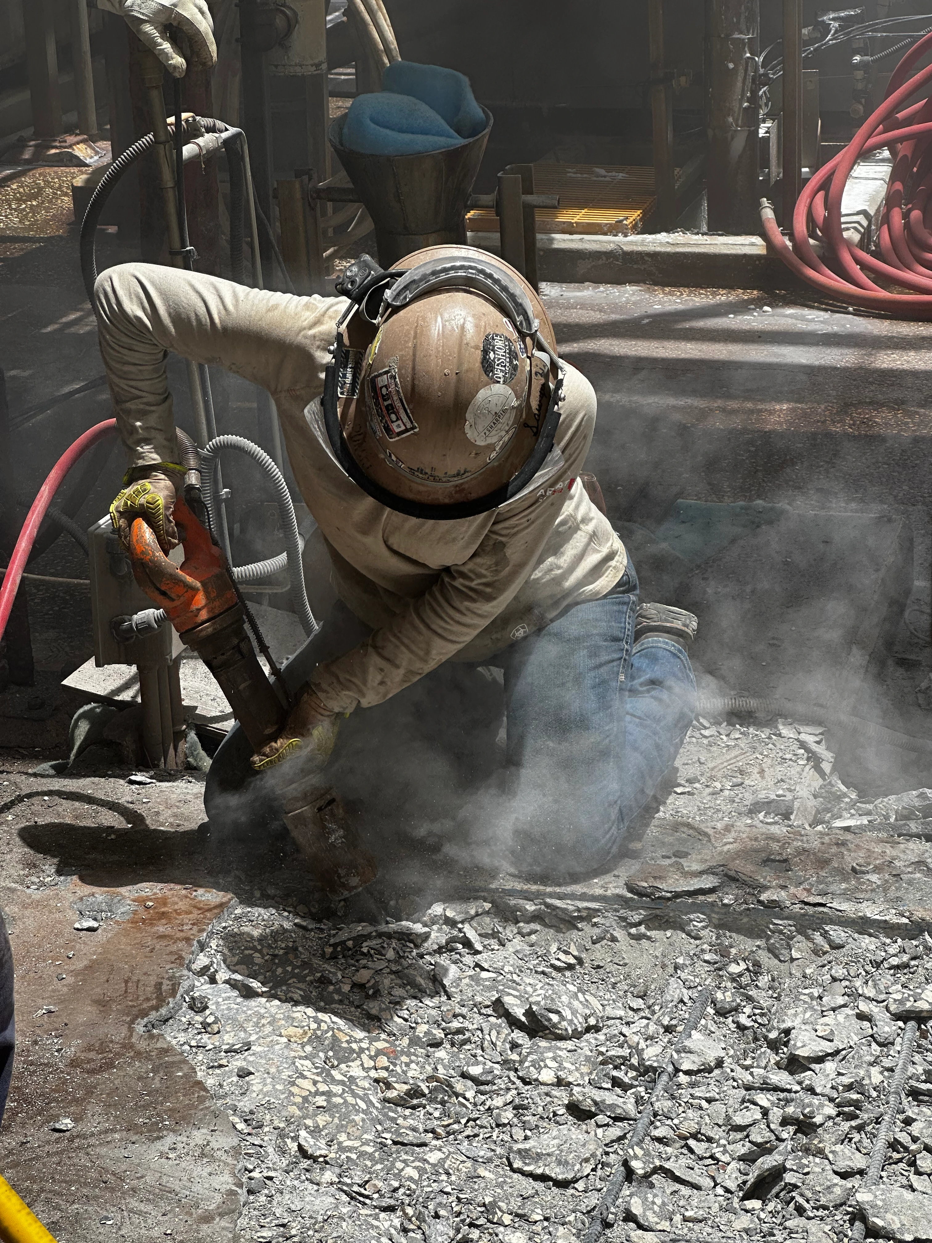 MIC crew performing concrete demolition on centrifuge foundation during industrial facility shutdown